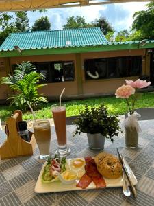 a table with a plate of food and two drinks at Kama Siri Koh Kood in Ko Kood +88 photos