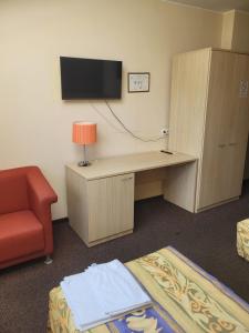a room with a desk and a tv and a chair at RV kavinė motelis in Salaperaugis