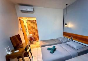 a bedroom with a bed and a desk with a green object on it at Buton Backpacker Lodge in Bandung