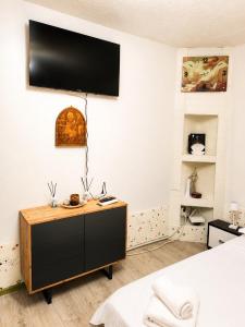 a bedroom with a dresser with a television on the wall at Best view house in Orşova
