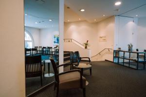 a waiting room with chairs and tables and a staircase at Hotel Zofingen in Zofingen