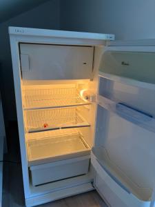 an empty refrigerator with its door open in a kitchen at L 'Écrin du Lac et Parkings in Veyrier-du-Lac