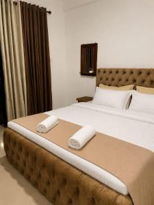 a bedroom with a large bed with two towels on it at Leo's Cozy Cabin in Ella
