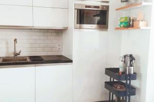 a kitchen with white cabinets and a sink at 27m with terrace - first row sea view in Six-Fours-les-Plages