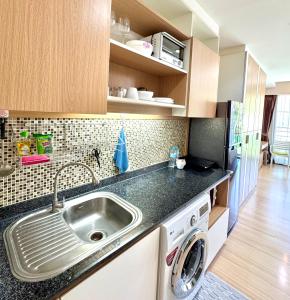 a kitchen with a sink and a washing machine at Nai Thon Condo Unit in Nai Thon Beach