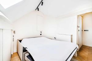 a bedroom with a white bed in a room at Charming Studio 2P - Marais in Paris