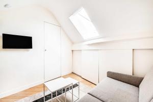 a living room with a couch and a tv at Charming Studio 2P - Marais in Paris