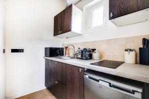a kitchen with wooden cabinets and a counter top at Charming Studio 2P - Marais in Paris