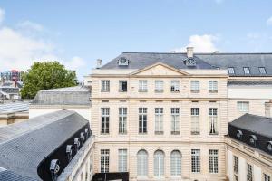 a large building with a train in front of it at Charming Studio 2P - Marais in Paris