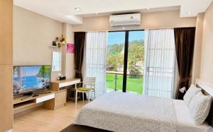 a bedroom with a bed and a tv and a window at Nai Thon Condo Unit in Nai Thon Beach