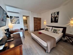 a bedroom with a large bed with a desk and a desk at Studio Alizé 724 in Saint-François