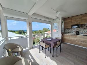 a kitchen and dining room with a table and chairs at Studio Alizé 724 in Saint-François +8 photos