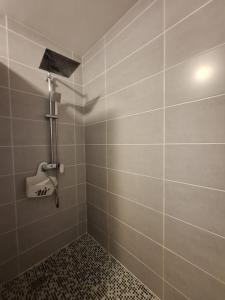 a tiled bathroom with a shower with a shower head at Studio Alizé 724 in Saint-François