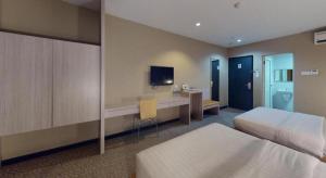 a hotel room with two beds and a desk and a tv at Clover Hotel in Johor Bahru +98 photos