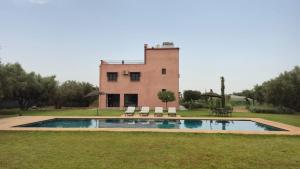 a house with a pool in front of a building at Le Paisible Atlas in Marrakesh