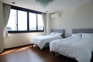 two beds in a room with large windows at Villa aco's in Ako +35 photos