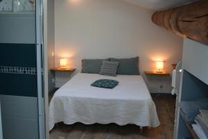 a bedroom with a bed with two lamps on two tables at L'Entracte de Grignan pour 6 personnes in Grignan