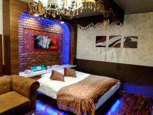 a bedroom with a bed and a brick wall at ホテルメイプル in Odate