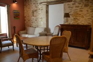 a living room with a table and chairs and a couch at L'Entracte de Grignan pour 6 personnes in Grignan