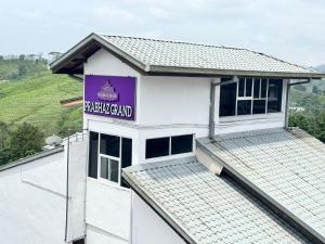a white building with a purple sign on it at Prabhaz grand villa in Hatton