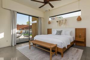 a bedroom with a large bed and a balcony at Windsong Modern compound w pool spa in Yucca Valley +40 photos