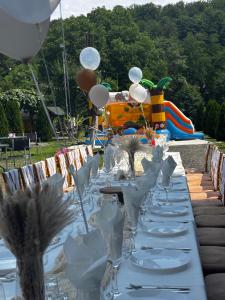 a long table with plates and wine glasses on it at CASA HOBAN in Baia Mare