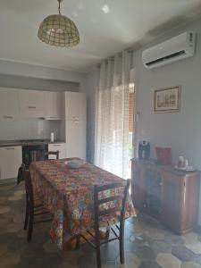 a dining room with a table and chairs and a kitchen at Holiday house daviale in Schisò