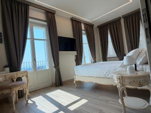 a bedroom with a white bed and windows at Villa Regina in Cisterna dʼAsti
