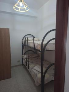 a couple of bunk beds in a room with a light at Holiday house daviale in Schisò