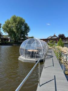 a table in a cage on a dock in the water at Hotel Nenufar Premium in Kościan +14 photos