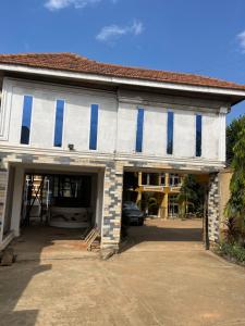 a white and blue building with a car parked in it at Serenity homes Uganda in Mbale