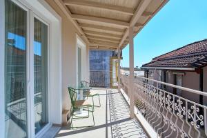 a balcony with two chairs and awning on a building at Irida Home in Parga