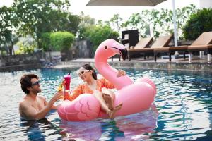a man and woman in a pool with an inflatable flamingo at Hyatt Regency Ahmedabad in Ahmedabad
