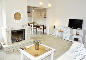 a living room with a fireplace and a tv at Villa Lakki Heated round pool Jacuzzi in Lákkoi