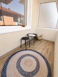 a room with a rug and two stools and a window at Къща за гости Беглик Таш 2 in Primorsko