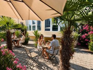 a group of people sitting at a table under an umbrella at Къща за гости Беглик Таш 2 in Primorsko +9 photos