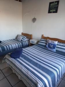 two beds sitting next to each other in a room at Arniston Cottage in Arniston