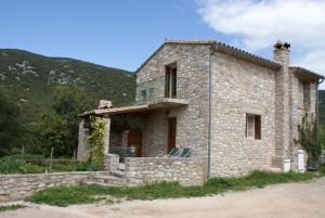 a stone house with a balcony on top of it at Bergerie de la buèges in Saint-André-de-Buèges