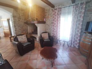 a living room with two chairs and a fireplace at Bergerie de la buèges in Saint-André-de-Buèges