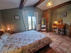 a bedroom with a bed and a table and a desk at Bergerie de la buèges in Saint-André-de-Buèges +20 photos