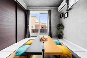a living room with a table and yellow and blue chairs at The Shelbourne Furano in Furano