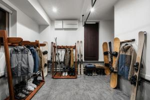 a room with skis and snowboards on a wall at The Shelbourne Furano in Furano +58 photos