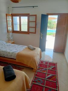 a bedroom with two beds and a door to a yard at Room in Villa Dar Albatros in Sidi Kaouki +154 photos