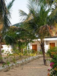 a resort with palm trees in front of a building at FR Resort in Pottuvil