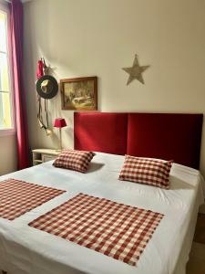 a bedroom with a large bed with a red headboard at Tournefeuille La Cure in Saint-Émilion