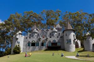 un château sur une colline avec des gens devant lui dans l'établissement Village Le Canton, à Teresópolis