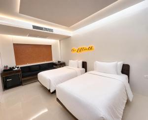 two beds in a room with a couch and a chalkboard at The 50th Uthai Thani in Uthai Thani +18 photos