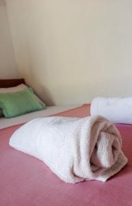 a white towel is laying on a bed at FR Resort in Pottuvil