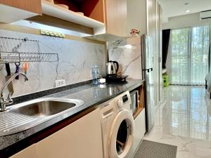 a kitchen with a sink and a washing machine at Супер апартаменты Найтон Naithon in Nai Thon Beach
