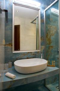 a bathroom with a large white sink and a mirror at Irida Home in Parga +11 photos